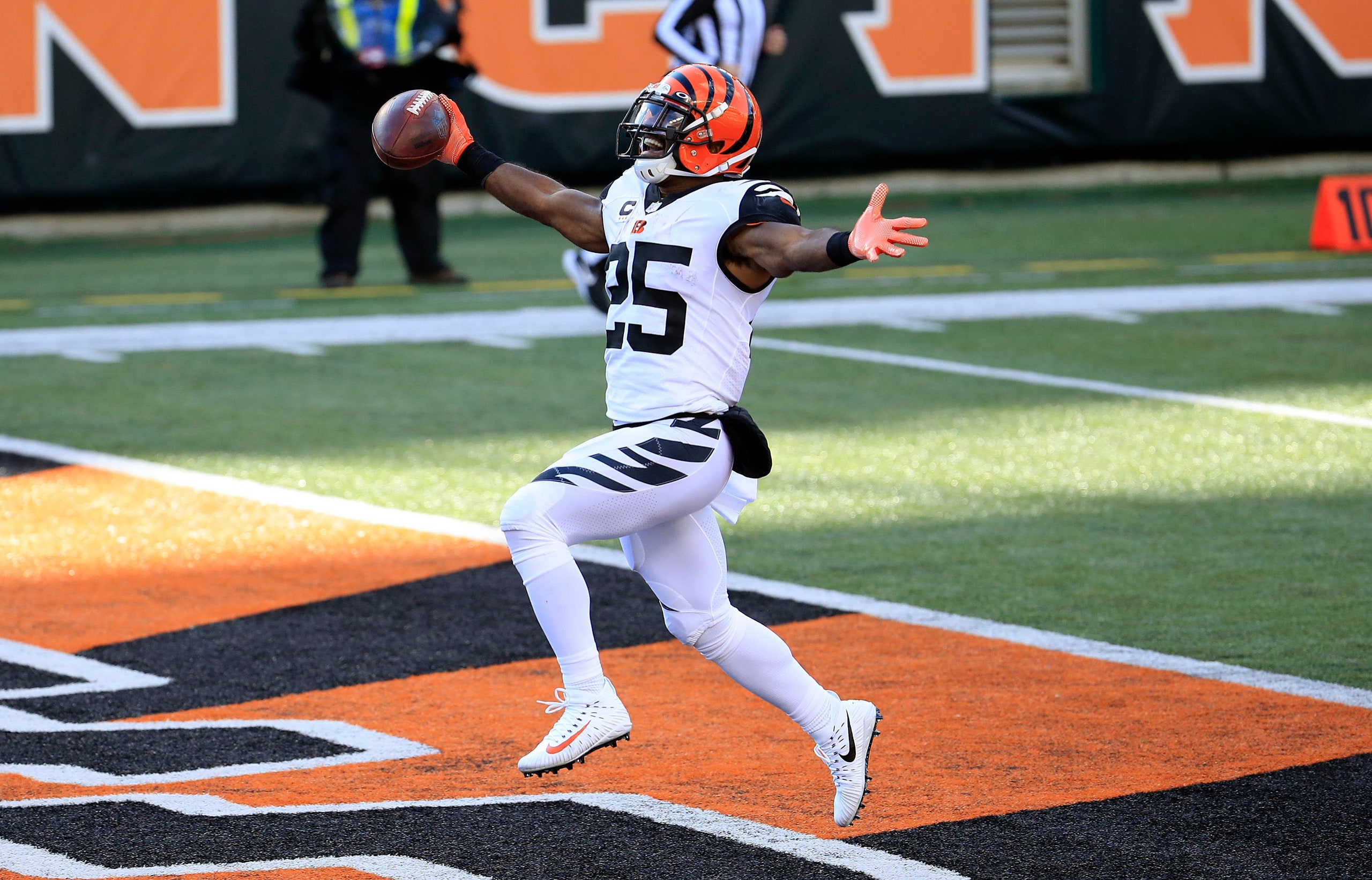 A Cincinnati Bengals football player runs over the finish line with his hands outstretched joyously