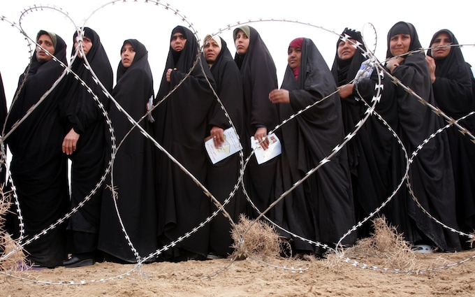 Iraqi women queue to vote behind barbed wire